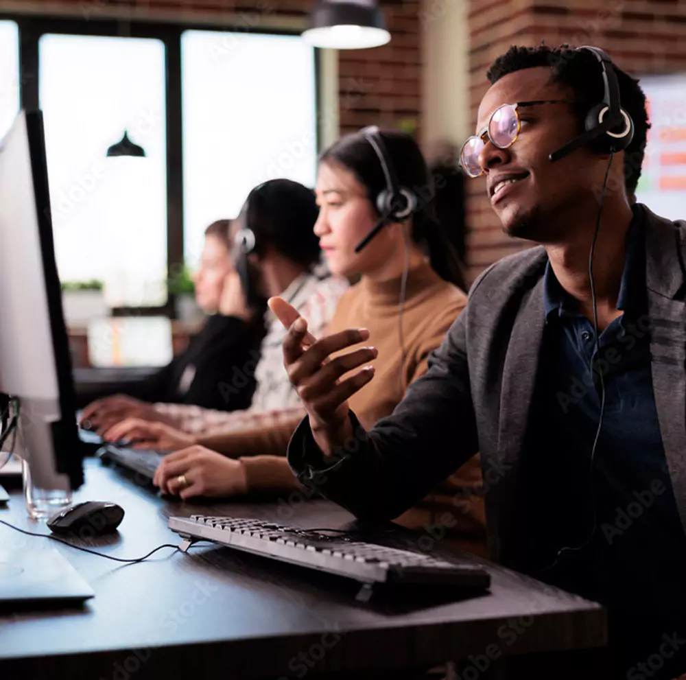 QueueDial call center rep talking on phone next to computer